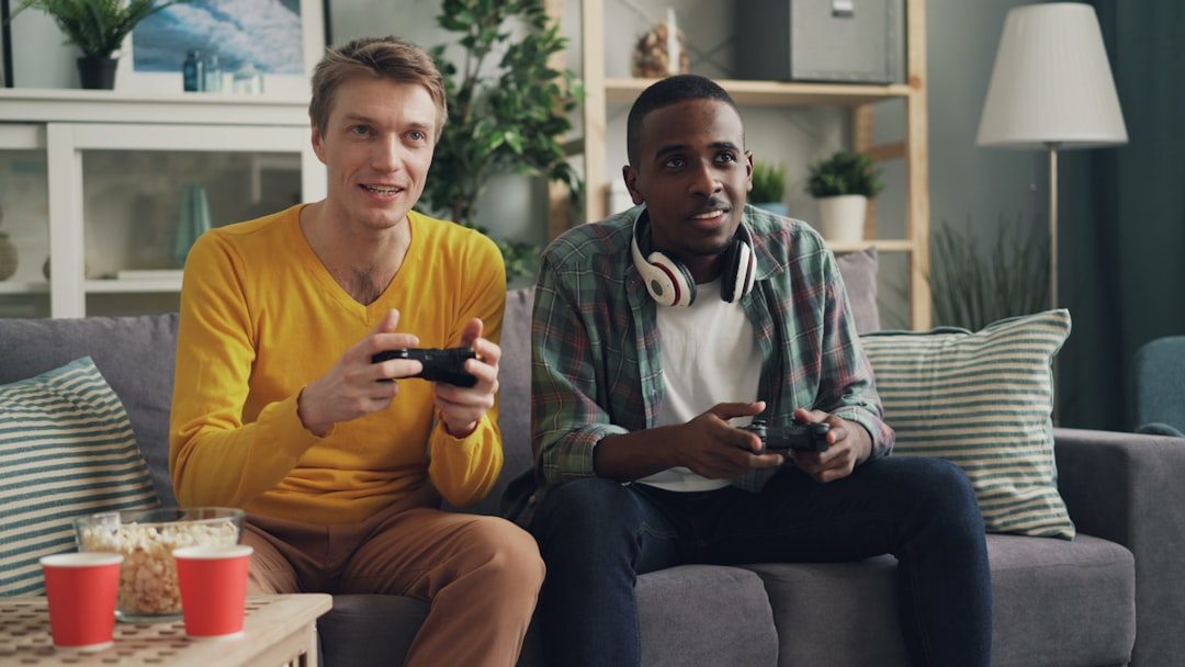 Two friends laughing while playing a couch co-op game